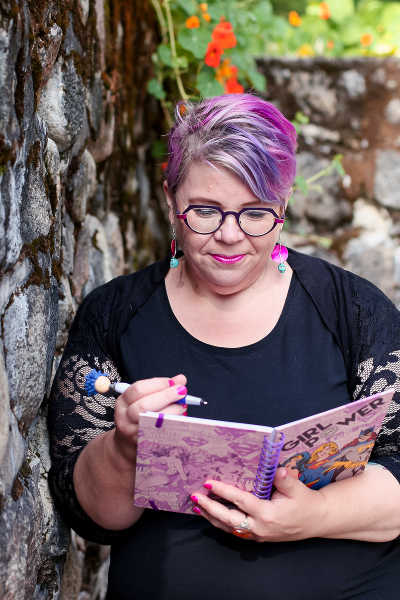 Merja Toppi kirjoittamassa vihkoon, jonka kannessa lukee "Girl power".