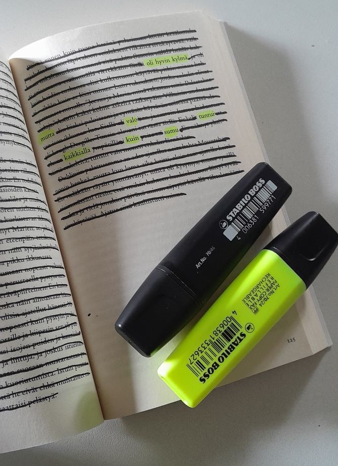 Avonainen kirja, josta on yliviivattu suurin osa sanoista. Jäljelle jää muutama sana eri riveille, ja niistä muodostuu runo: "oli hyvin kylmä mutta valo tuntui kaikkialla kuin sumu".